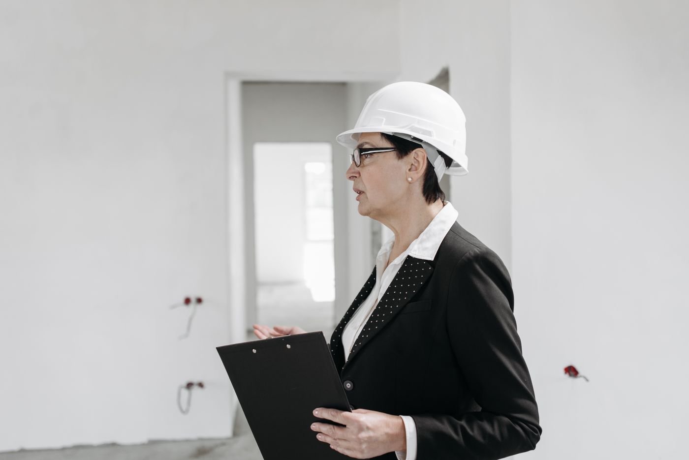Inspection engineer wearing a hard hat reviewing site documentation